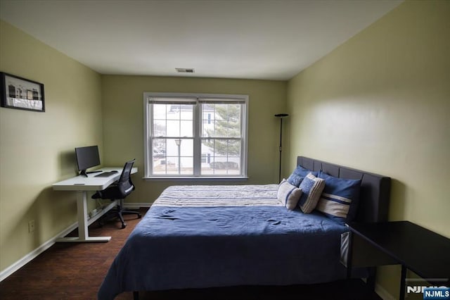 bedroom with dark wood-style floors, baseboards, and visible vents