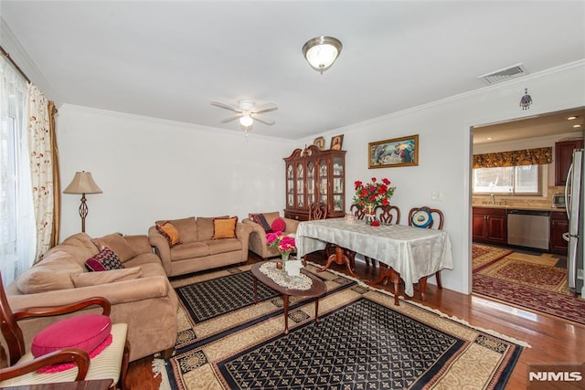 living room featuring ceiling fan, ornamental molding, sink, and wood-type flooring