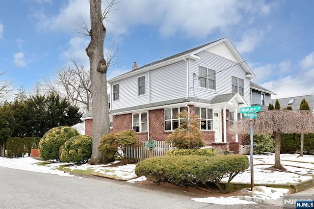 view of property exterior featuring fence and brick siding