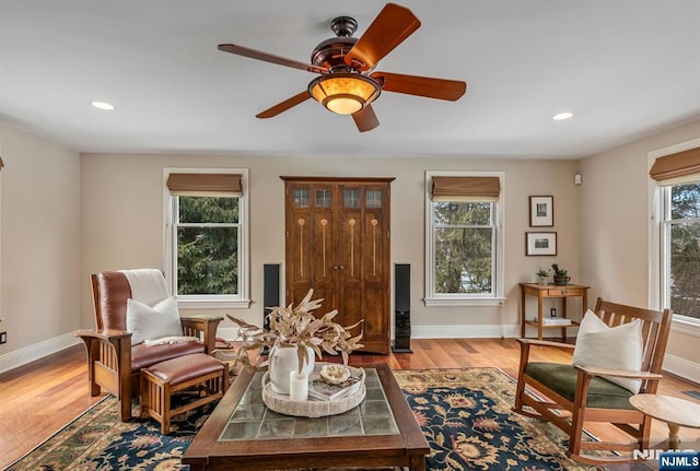 sitting room with baseboards, wood finished floors, and recessed lighting