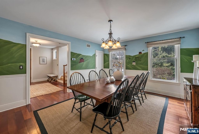 dining room with wood-type flooring, visible vents, a notable chandelier, and wainscoting