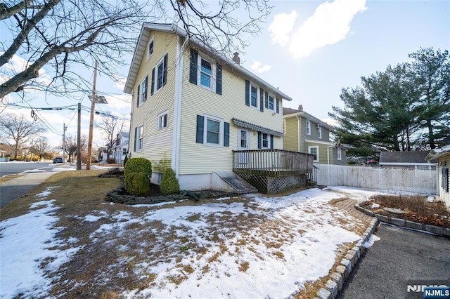 snow covered property with a wooden deck