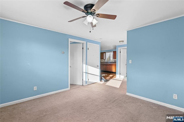 interior space with ornamental molding, ceiling fan, and light colored carpet