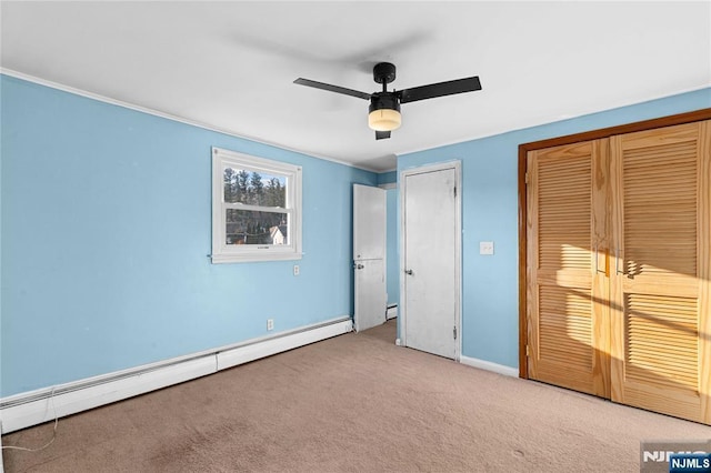 unfurnished bedroom featuring a baseboard heating unit, ceiling fan, light colored carpet, and two closets