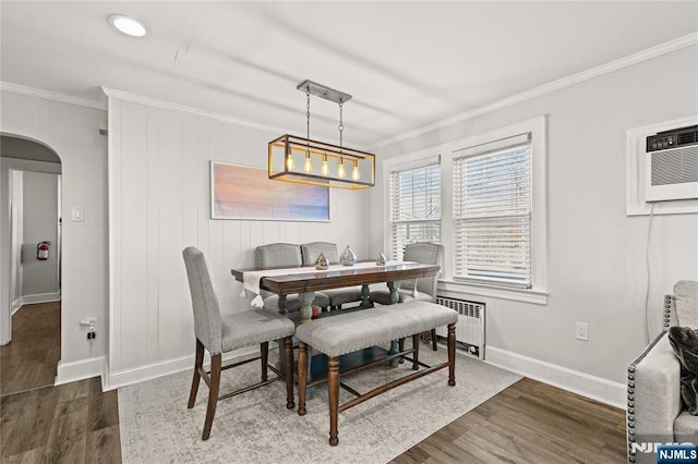 dining area with ornamental molding, radiator, a wall mounted air conditioner, and dark hardwood / wood-style floors