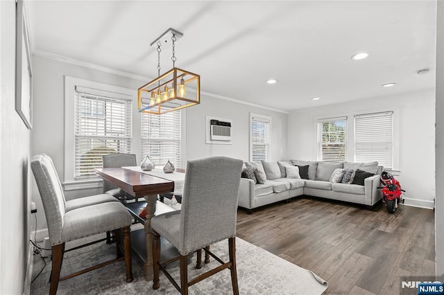 dining room with an AC wall unit, crown molding, dark hardwood / wood-style floors, and a notable chandelier