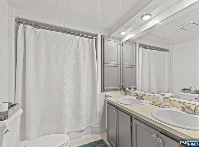 full bathroom with toilet, vanity, and shower / bath combo with shower curtain