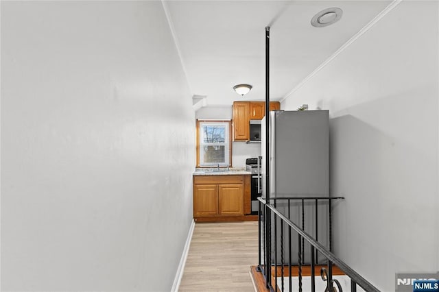 kitchen with light hardwood / wood-style floors, sink, stove, and crown molding