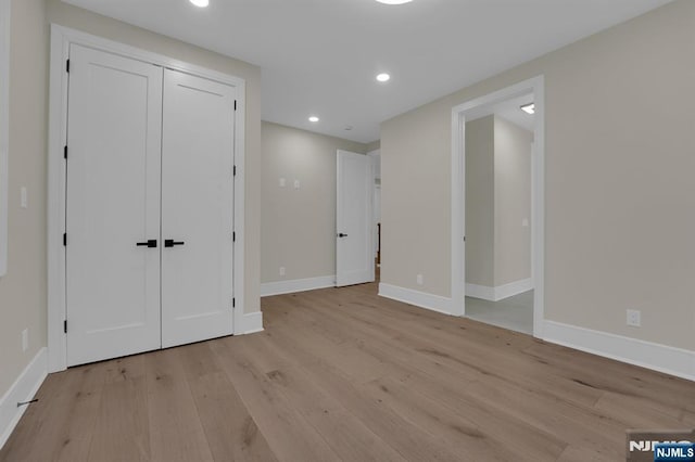 unfurnished bedroom featuring a closet and light hardwood / wood-style flooring