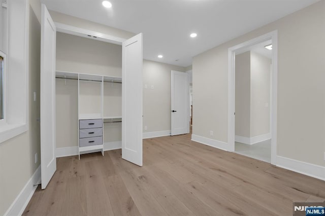 unfurnished bedroom with light hardwood / wood-style flooring and a closet