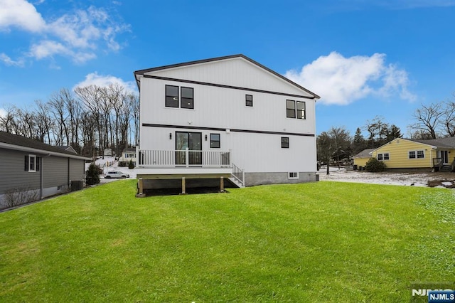 rear view of property with a yard and a wooden deck