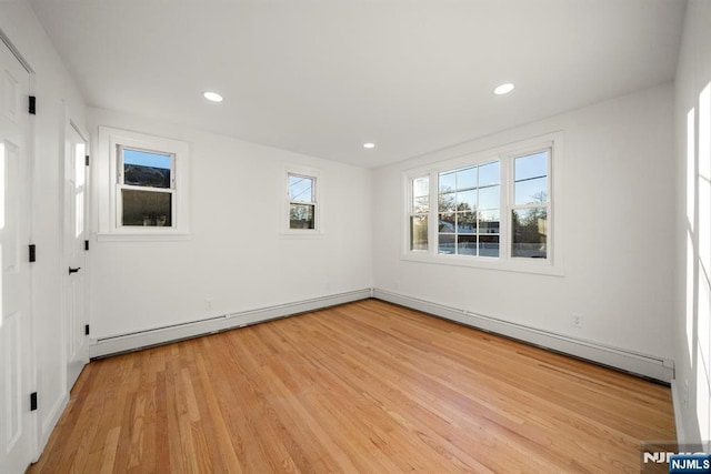 spare room featuring light wood-type flooring and a baseboard radiator