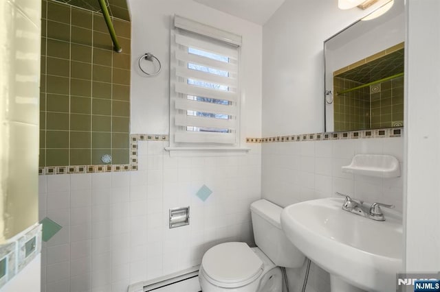 bathroom featuring baseboard heating, sink, tile walls, and toilet