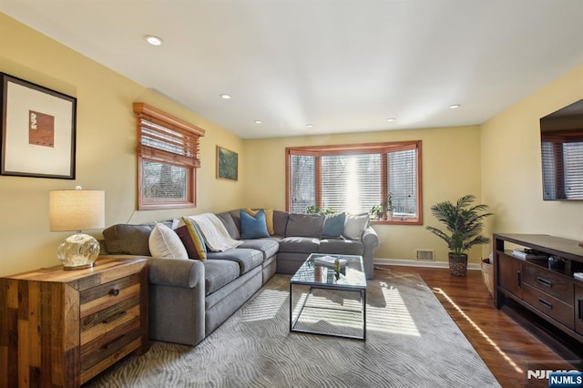 living area featuring dark wood-style floors, recessed lighting, visible vents, and baseboards