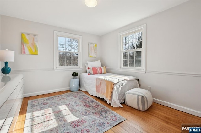 bedroom with baseboards and wood finished floors