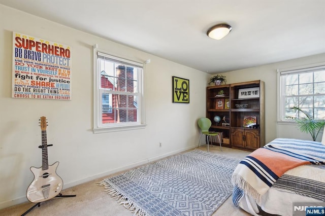 bedroom with light carpet and baseboards