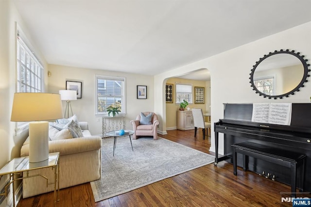 sitting room featuring dark wood-style floors and arched walkways