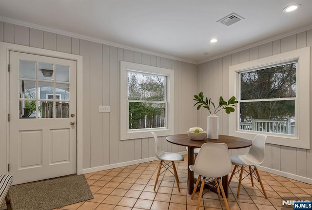 dining area with ornamental molding, light tile patterned flooring, visible vents, and baseboards