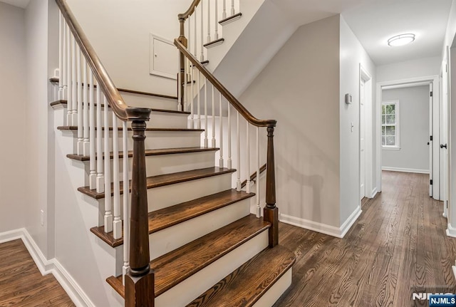 staircase featuring wood finished floors and baseboards