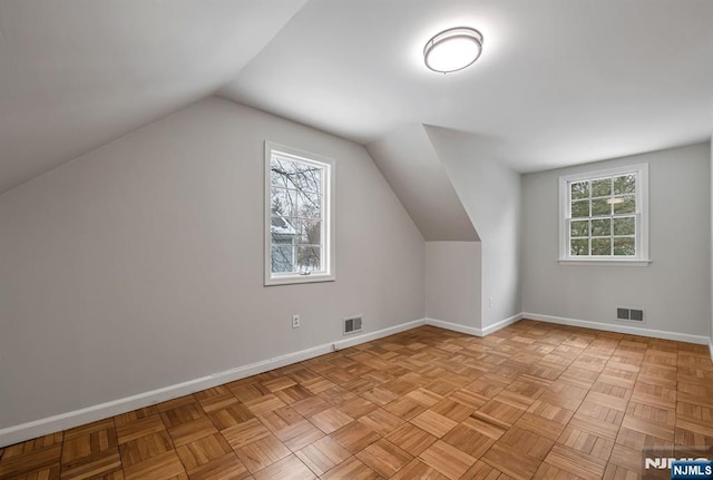 additional living space featuring visible vents, plenty of natural light, and baseboards