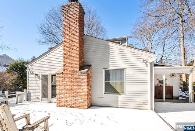 rear view of house featuring a chimney, a patio area, and fence