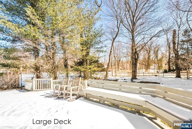 snowy yard featuring fence