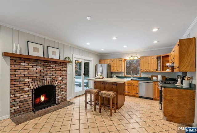 kitchen with a kitchen island, appliances with stainless steel finishes, a breakfast bar area, open shelves, and a sink