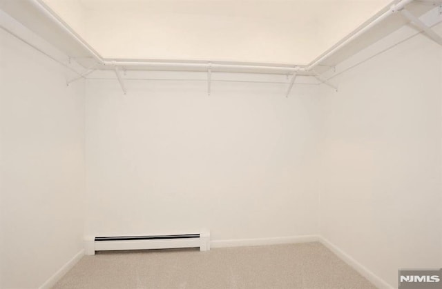 spacious closet featuring a baseboard heating unit and carpet flooring