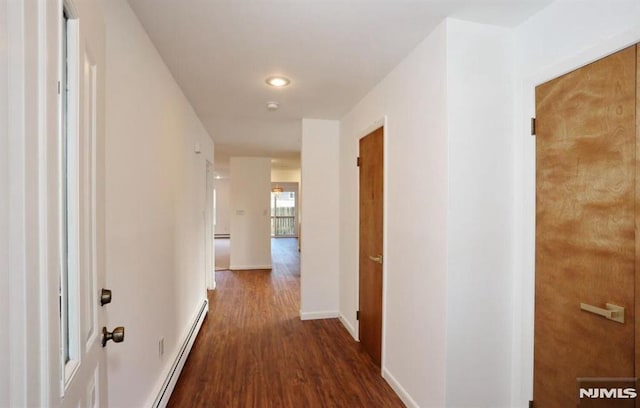 hall with a baseboard radiator and dark hardwood / wood-style flooring