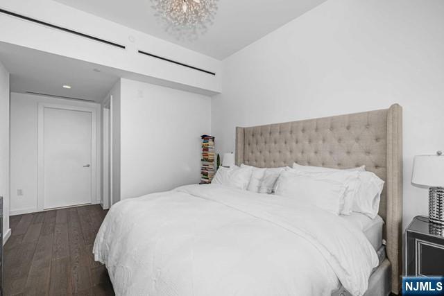 bedroom featuring dark hardwood / wood-style floors and an inviting chandelier