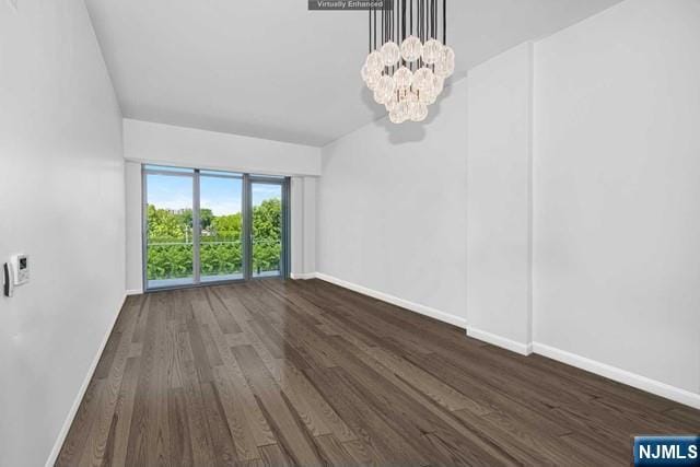 unfurnished room with a chandelier and dark hardwood / wood-style flooring