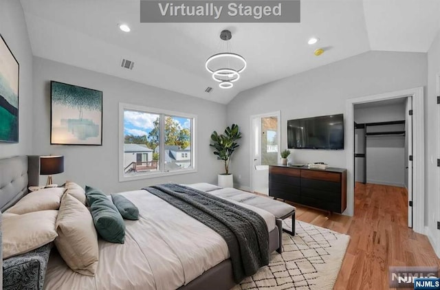 bedroom featuring light hardwood / wood-style flooring and lofted ceiling