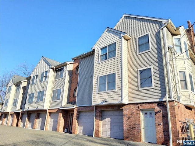 exterior space featuring brick siding and community garages