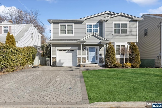 view of front of property with a garage, stone siding, decorative driveway, and a front yard