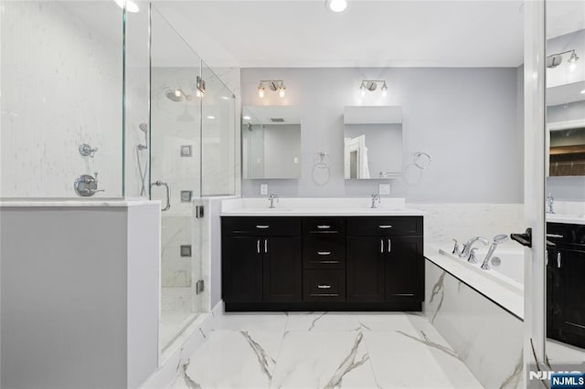 full bath featuring double vanity, a sink, a marble finish shower, and a bath