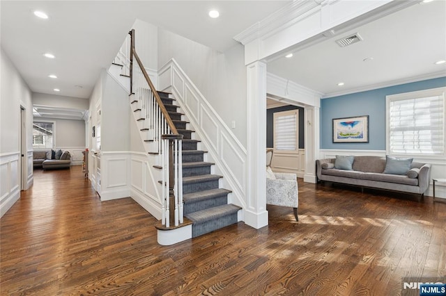 stairs featuring recessed lighting, a decorative wall, wood finished floors, visible vents, and ornamental molding