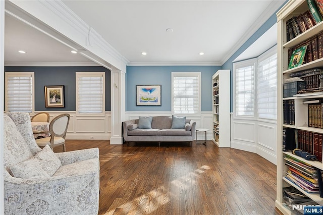 sitting room with a wainscoted wall, dark wood-type flooring, recessed lighting, and crown molding