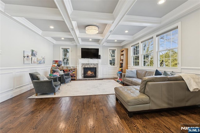 living area with dark wood-style floors, recessed lighting, beam ceiling, and a lit fireplace