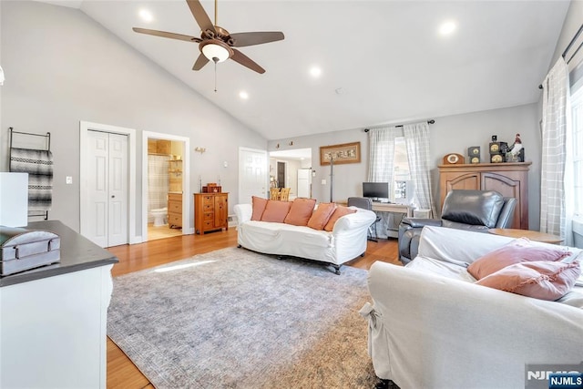 living room featuring high vaulted ceiling, ceiling fan, and light hardwood / wood-style flooring