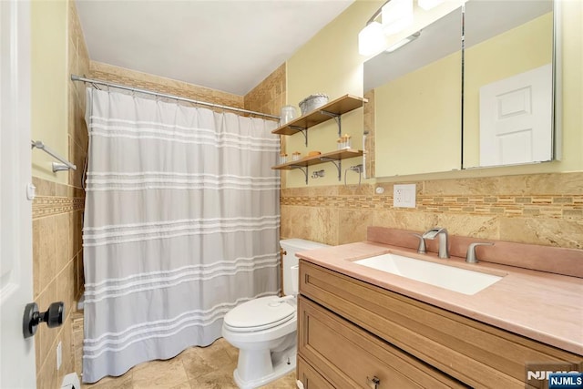 bathroom with toilet, tile walls, and vanity