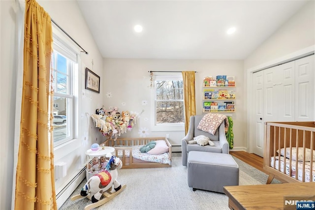 bedroom with a baseboard radiator, a closet, and vaulted ceiling