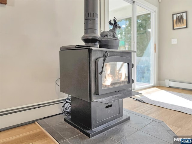 details with a wood stove, hardwood / wood-style flooring, and a baseboard heating unit