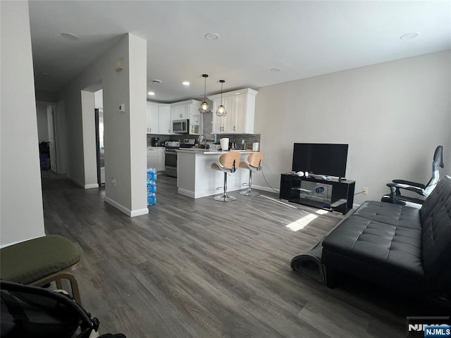 living room with recessed lighting, dark wood finished floors, and baseboards