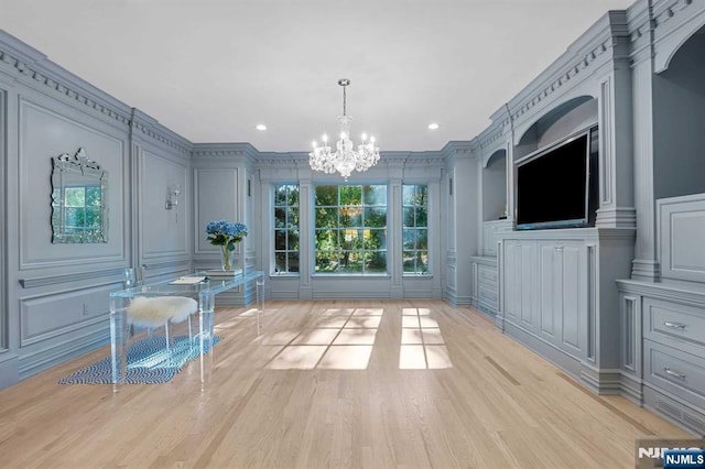 interior space featuring crown molding, a chandelier, and light hardwood / wood-style floors