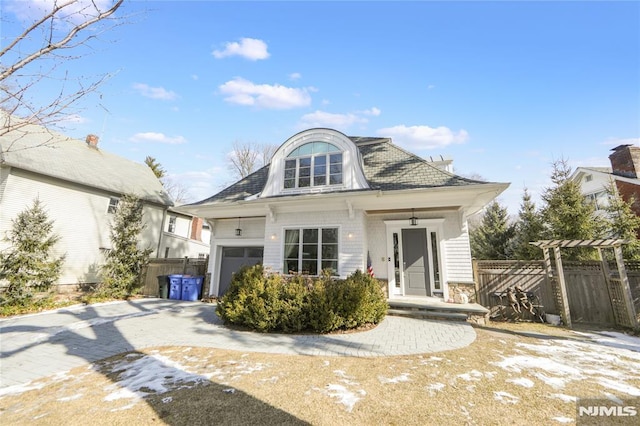 view of front facade with fence, driveway, and an attached garage