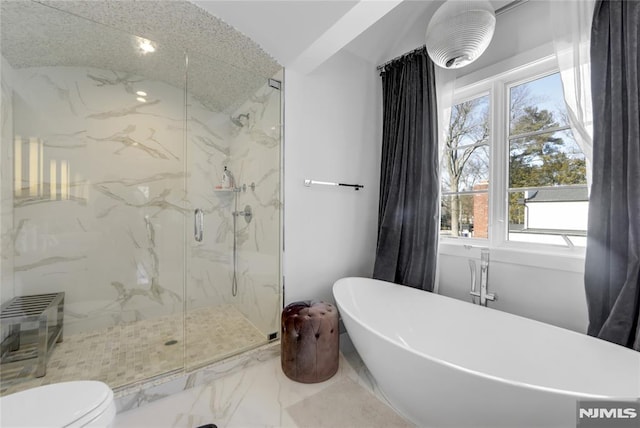 bathroom with marble finish floor, a marble finish shower, and a soaking tub