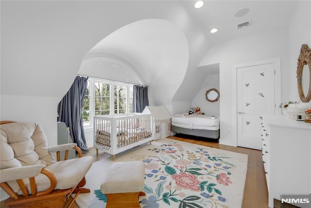 bedroom with visible vents, vaulted ceiling, wood finished floors, and recessed lighting