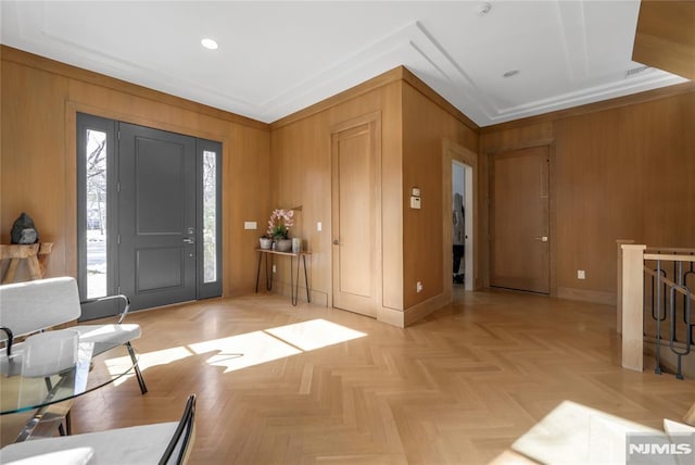 entryway with baseboards, recessed lighting, wooden walls, and ornamental molding