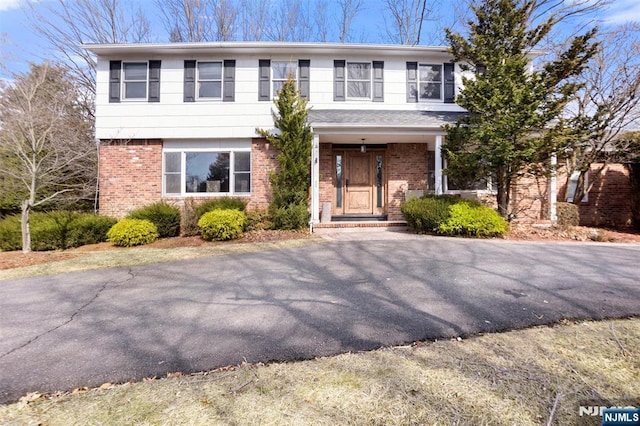 colonial house featuring brick siding