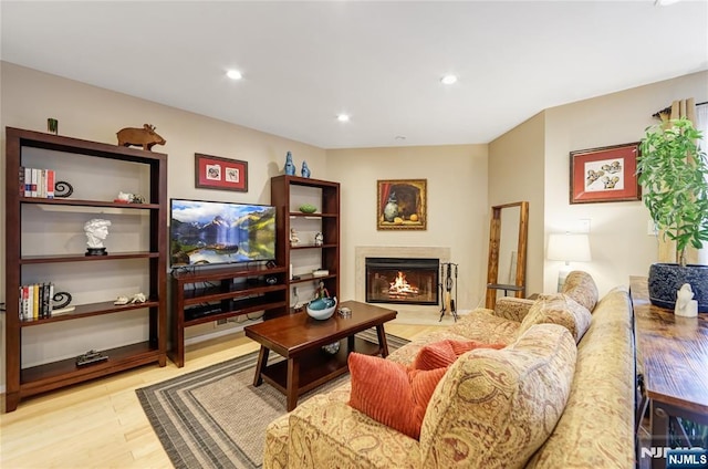 living area featuring light wood-style floors, a premium fireplace, and recessed lighting